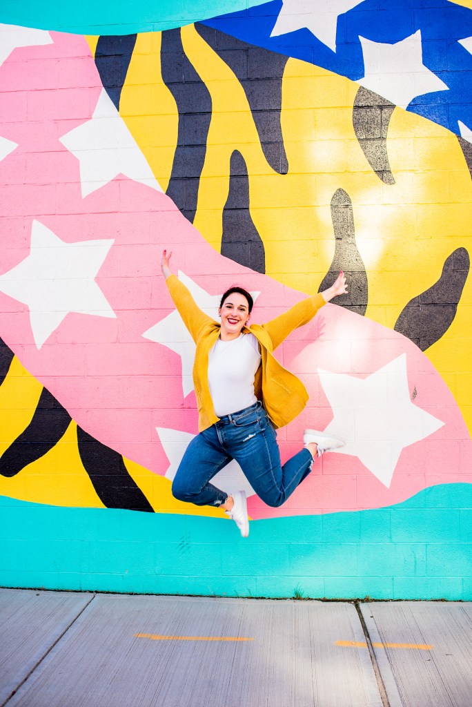 lady jumping in front of tiger mural in ohio city